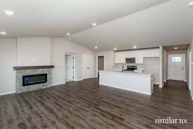 9383 Modena Ln, West Des Moines, IA 50266 - unfurnished living room featuring vaulted ceiling, dark wood finished floors, a fireplace, and recessed lighting