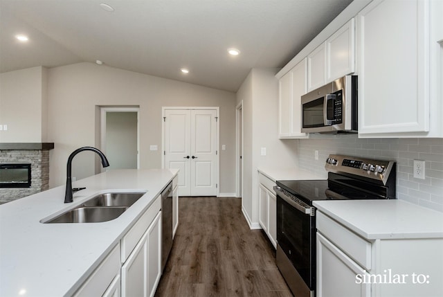 9383 Modena Ln, West Des Moines, IA 50266 - kitchen with stainless steel appliances, backsplash, dark wood-style flooring, white cabinetry, and vaulted ceiling