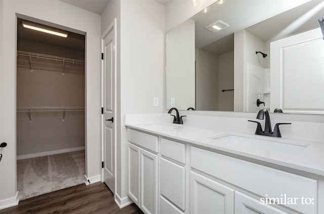9383 Modena Ln, West Des Moines, IA 50266 - bathroom with wood finished floors, double vanity, and a spacious closet