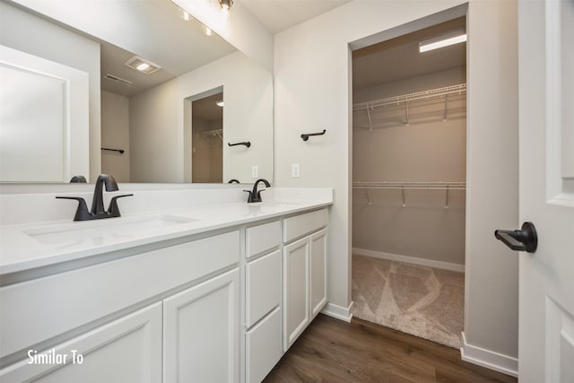715 Linden St, Carlisle, IA 50047 - full bath featuring double vanity, wood finished floors, and a walk in closet