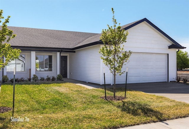 715 Linden St, Carlisle, IA 50047 - single story home with concrete driveway, a garage, a front yard, and a shingled roof