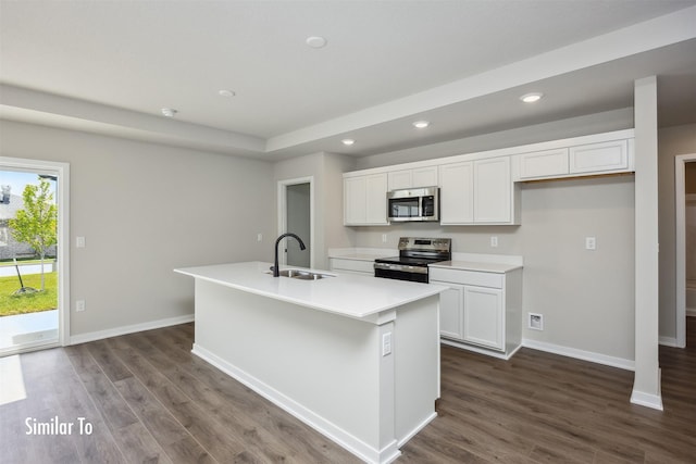 715 Linden St, Carlisle, IA 50047 - kitchen featuring stainless steel appliances, recessed lighting, white cabinets, dark wood-type flooring, and a kitchen island with sink