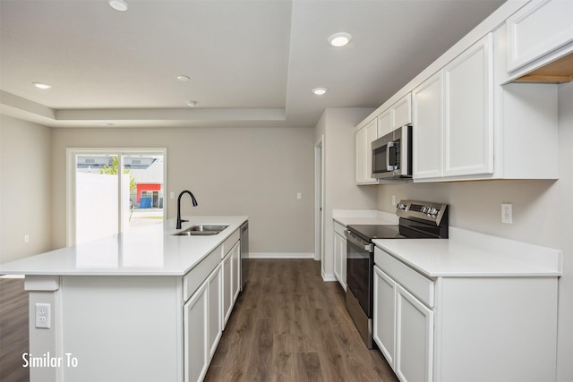 715 Linden St, Carlisle, IA 50047 - kitchen with stainless steel appliances, dark wood-style floors, an island with sink, recessed lighting, and white cabinets