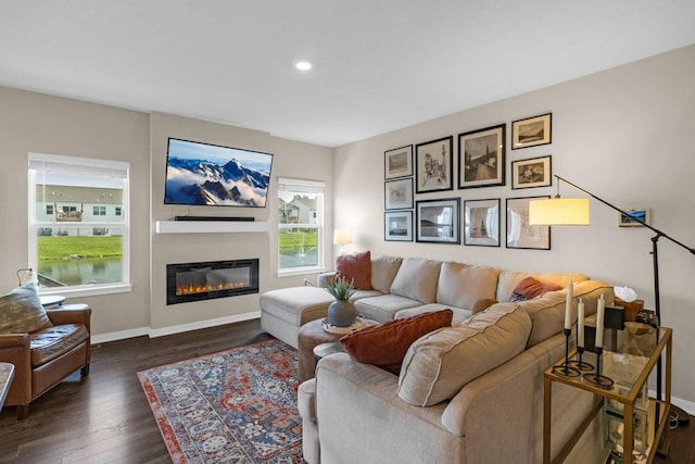 210 SE Willow Run Ln, Ankeny, IA 50021 - living area featuring dark wood-type flooring, a glass covered fireplace, and recessed lighting