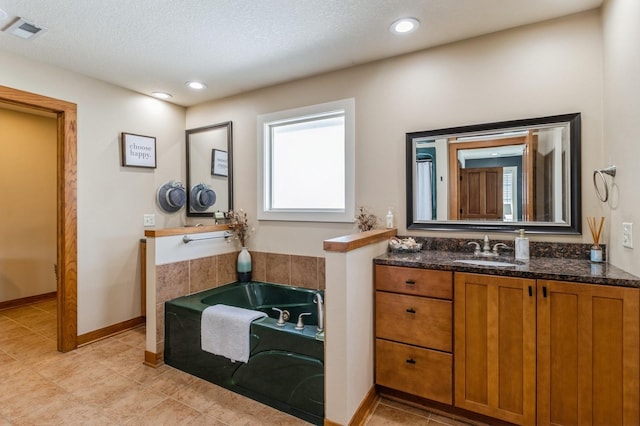 2687 NW 165th Ln, Clive, IA 50325 - full bath featuring vanity, a bath, tile patterned floors, recessed lighting, and a textured ceiling