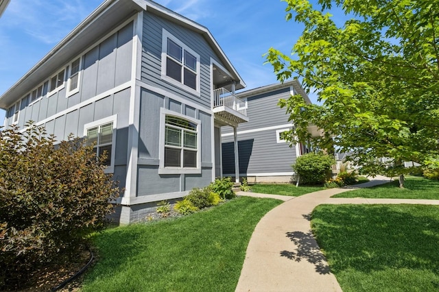 2687 NW 165th Ln, Clive, IA 50325 - view of home's exterior featuring a balcony, a lawn, and board and batten siding