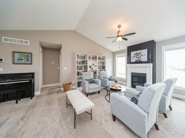 712 Mallard Pointe Dr NW, Bondurant, IA 50035 - living area with lofted ceiling, light carpet, ceiling fan, and a glass covered fireplace