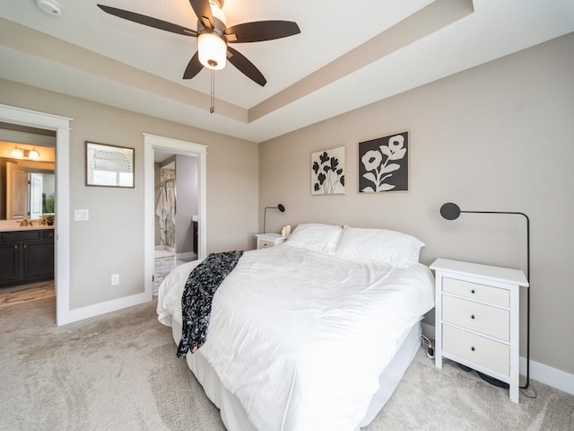 712 Mallard Pointe Dr NW, Bondurant, IA 50035 - bedroom with light carpet, ensuite bath, a tray ceiling, and ceiling fan