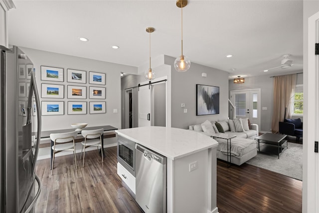 9622 NW 70th Ave, Johnston, IA 50131 - kitchen featuring stainless steel appliances, a barn door, dark wood-style flooring, decorative light fixtures, and recessed lighting