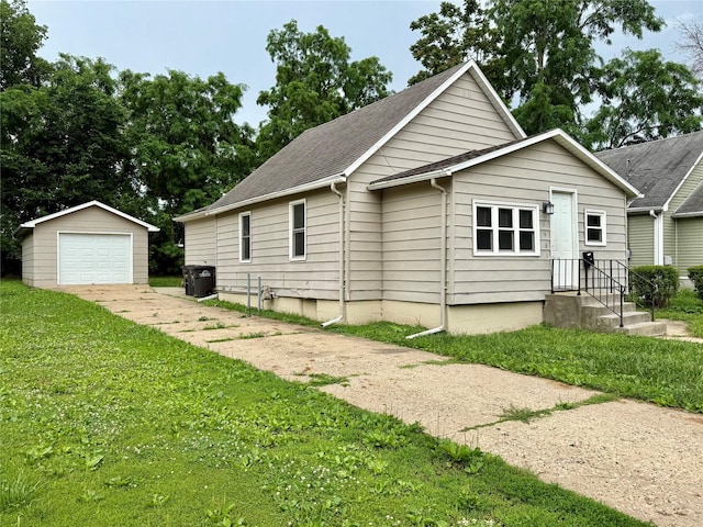 1431 E 19th St, Des Moines, IA 50316 - view of front facade featuring an outdoor structure, a detached garage, a front lawn, driveway, and roof with shingles