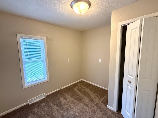 1431 E 19th St, Des Moines, IA 50316 - spare room with dark colored carpet and a textured ceiling