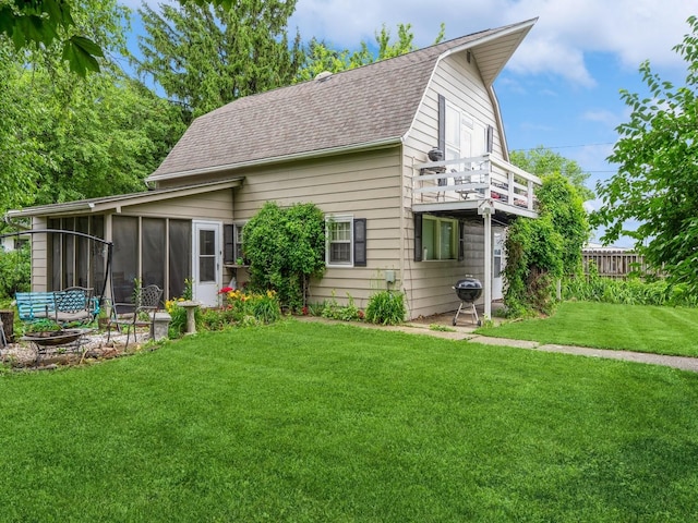 110 E 20th St N, Newton, IA 50208 - back of house featuring a sunroom, a lawn, roof with shingles, and a gambrel roof