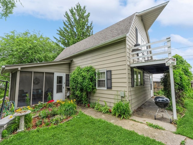 110 E 20th St N, Newton, IA 50208 - view of side of home with a balcony, a sunroom, and roof with shingles