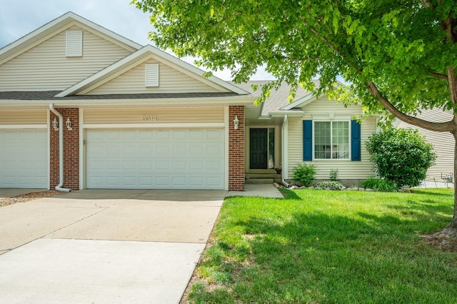 5514 SE 24th St, Des Moines, IA 50320 - view of front of home with a front lawn, concrete driveway, brick siding, and a garage