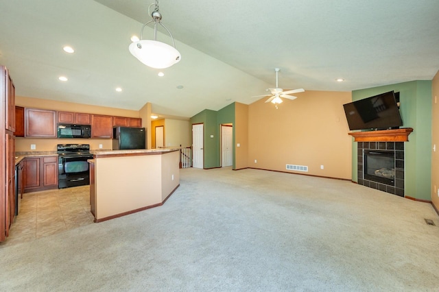 5514 SE 24th St, Des Moines, IA 50320 - kitchen with black appliances, open floor plan, lofted ceiling, light carpet, and a tile fireplace