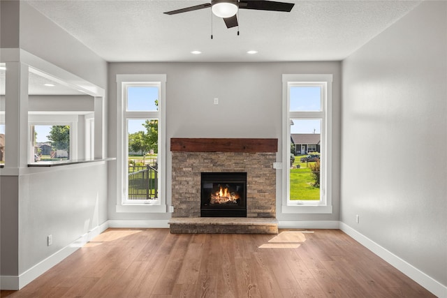 1217 NW Morningside Ct, Grimes, IA 50111 - unfurnished living room featuring a ceiling fan, a fireplace, hardwood / wood-style floors, healthy amount of natural light, and recessed lighting