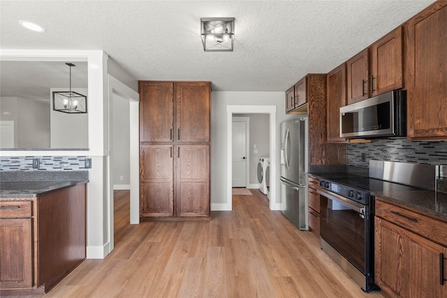 1217 NW Morningside Ct, Grimes, IA 50111 - kitchen featuring stainless steel appliances, washer / clothes dryer, light wood-style flooring, decorative backsplash, and a textured ceiling