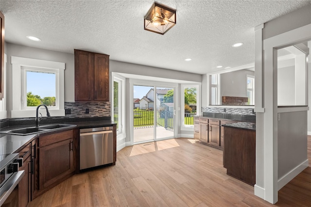 1217 NW Morningside Ct, Grimes, IA 50111 - kitchen featuring stainless steel dishwasher, dark countertops, backsplash, light wood-style floors, and recessed lighting