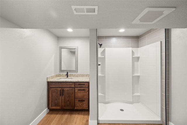 1217 NW Morningside Ct, Grimes, IA 50111 - bathroom with a stall shower, vanity, wood finished floors, and recessed lighting
