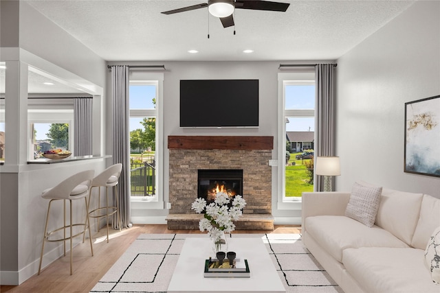 1217 NW Morningside Ct, Grimes, IA 50111 - living area with wood finished floors, a ceiling fan, a fireplace, recessed lighting, and a textured ceiling