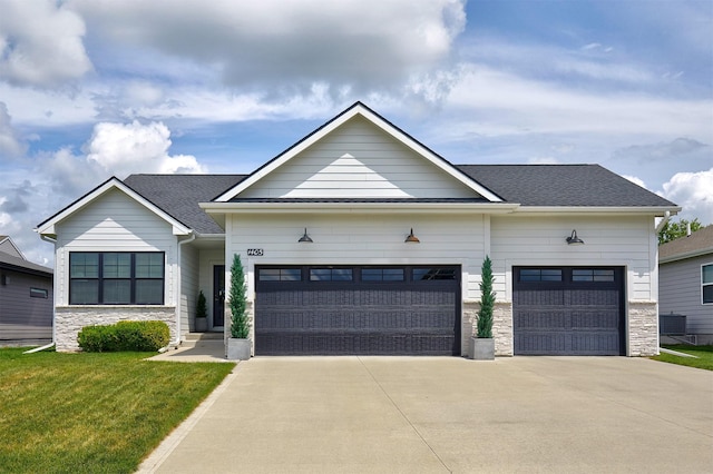 1405 NE Main St, Grimes, IA 50111 - view of front of house with a garage, stone siding, driveway, and a front lawn