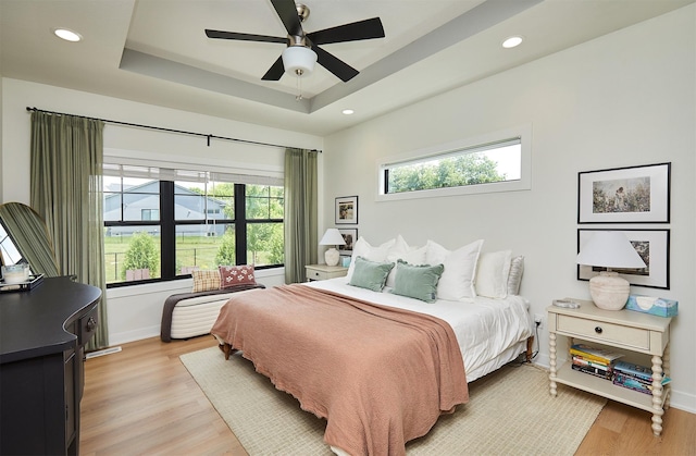 1405 NE Main St, Grimes, IA 50111 - bedroom featuring light wood-type flooring, a tray ceiling, recessed lighting, and ceiling fan