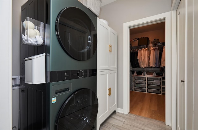 1405 NE Main St, Grimes, IA 50111 - laundry area featuring estacked washer and dryer, cabinet space, and light wood-type flooring