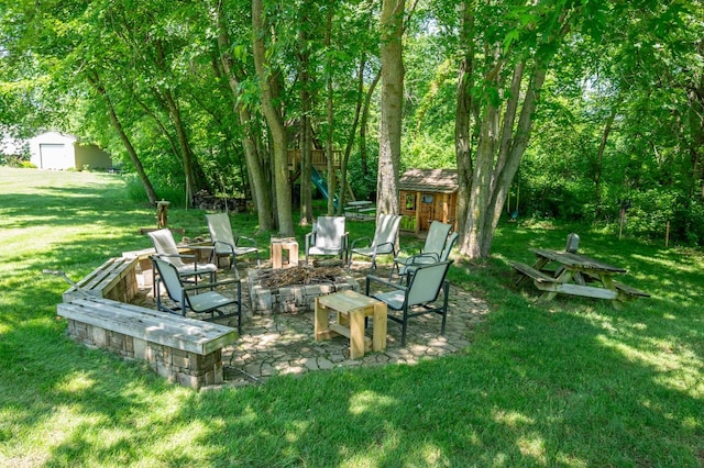 105 Everett Cir, Mingo, IA 50168 - view of green lawn featuring an outbuilding, a fire pit, and a patio area