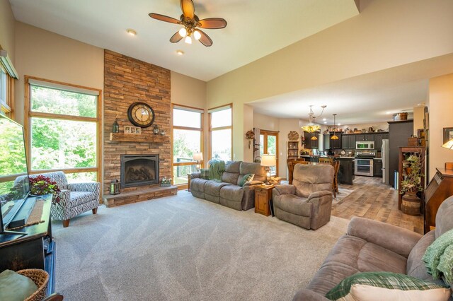 105 Everett Cir, Mingo, IA 50168 - living area featuring a ceiling fan, a fireplace, a towering ceiling, a chandelier, and light carpet