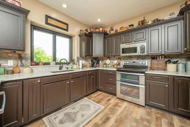 105 Everett Cir, Mingo, IA 50168 - kitchen featuring stainless steel appliances, decorative backsplash, light wood-type flooring, recessed lighting, and light stone countertops