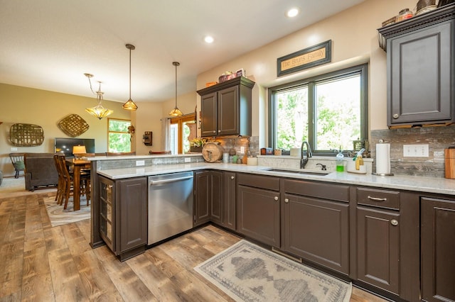 105 Everett Cir, Mingo, IA 50168 - kitchen featuring stainless steel dishwasher, decorative backsplash, a peninsula, light wood-style flooring, and hanging light fixtures