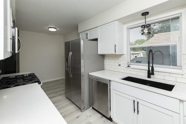 3113 E 36th Ct, Des Moines, IA 50317 - kitchen with stainless steel appliances, light wood finished floors, backsplash, light countertops, and a textured ceiling