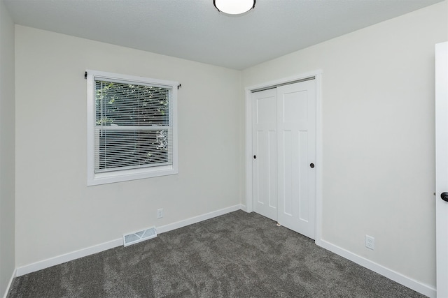 3113 E 36th Ct, Des Moines, IA 50317 - unfurnished bedroom featuring dark colored carpet and a closet