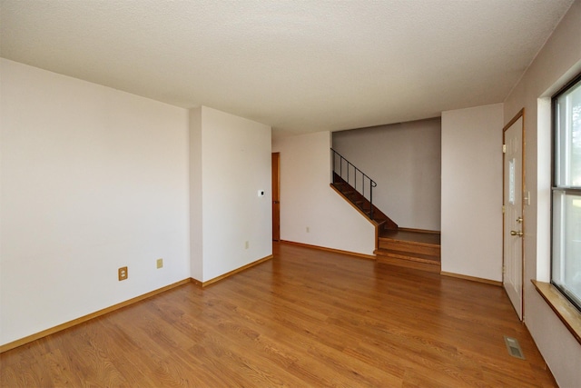 8628 Alpine Dr Unit C, Urbandale, IA 50322 - spare room featuring light wood-style flooring and stairway