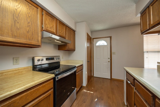 8628 Alpine Dr Unit C, Urbandale, IA 50322 - kitchen with stainless steel electric range, under cabinet range hood, wood finished floors, light countertops, and a textured ceiling