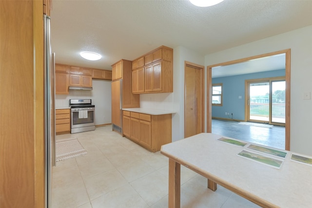 28453 530th Ave, Kelley, IA 50134 - kitchen featuring gas range, a textured ceiling, light countertops, under cabinet range hood, and light tile patterned floors