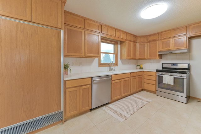 28453 530th Ave, Kelley, IA 50134 - kitchen featuring appliances with stainless steel finishes, under cabinet range hood, light countertops, tasteful backsplash, and a textured ceiling