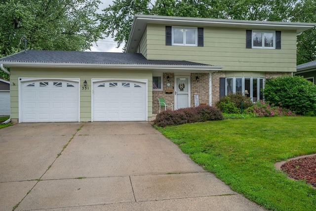 331 E 24th St N, Newton, IA 50208 - view of front of house featuring concrete driveway, a garage, a front yard, and brick siding