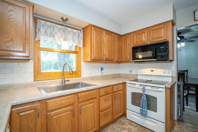 331 E 24th St N, Newton, IA 50208 - kitchen featuring black microwave, white range with electric cooktop, light countertops, brown cabinetry, and decorative backsplash
