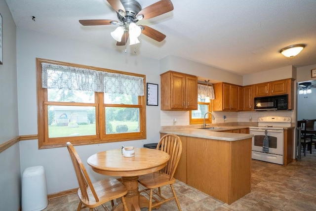 331 E 24th St N, Newton, IA 50208 - kitchen featuring black microwave, white range with electric cooktop, a peninsula, backsplash, and ceiling fan