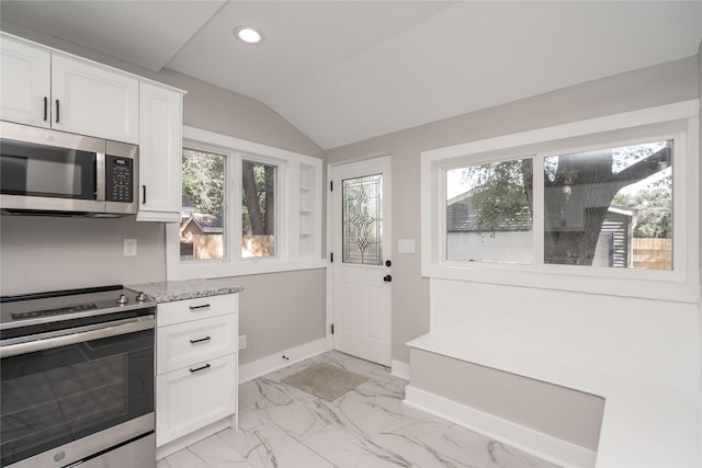 2715 Center St, Des Moines, IA 50312 - kitchen featuring appliances with stainless steel finishes, recessed lighting, white cabinetry, light marble finish floors, and lofted ceiling