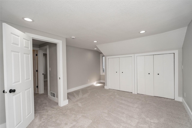 2715 Center St, Des Moines, IA 50312 - unfurnished bedroom with light colored carpet, two closets, recessed lighting, and a textured ceiling