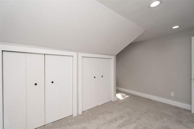 2715 Center St, Des Moines, IA 50312 - unfurnished bedroom featuring lofted ceiling, carpet, two closets, recessed lighting, and a textured ceiling