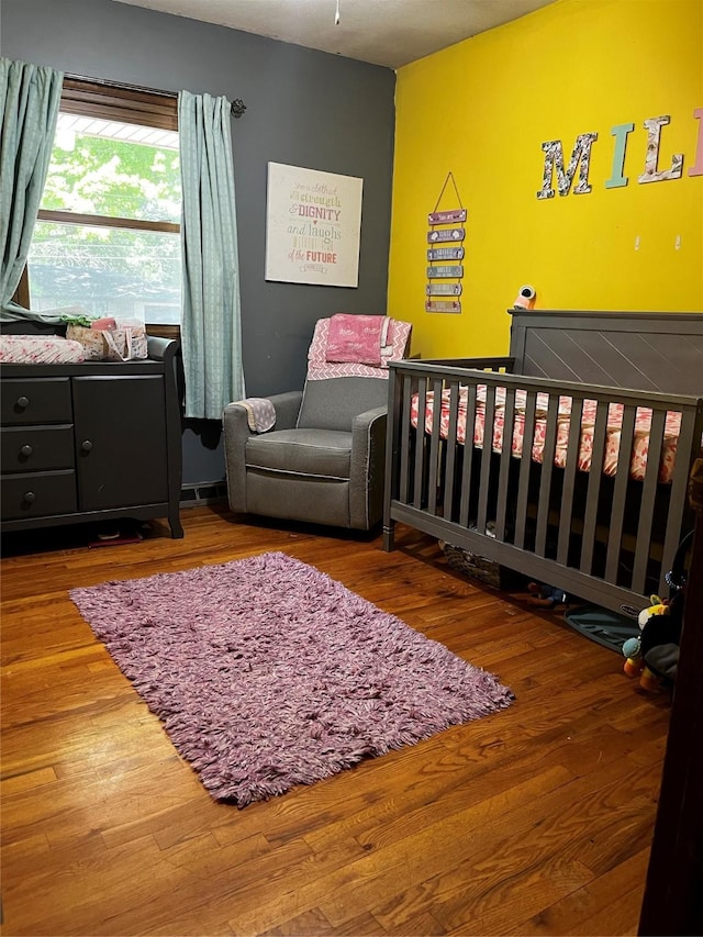 815 Knob Hill Dr, Des Moines, IA 50317 - bedroom with a crib and wood finished floors