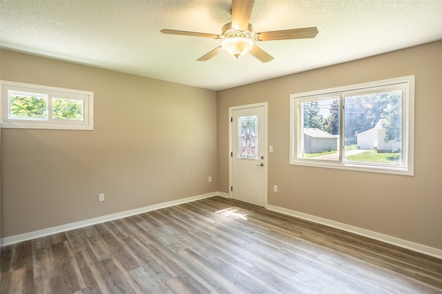 2311 Williams St, Des Moines, IA 50317 - empty room with wood finished floors, a ceiling fan, and a textured ceiling