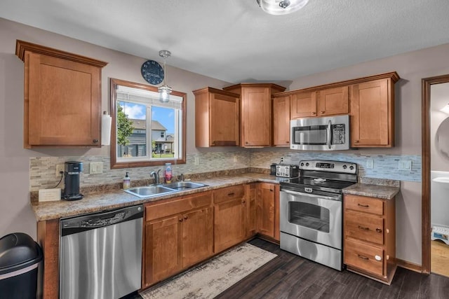 1329 Joshua Cir SE, Bondurant, IA 50035 - kitchen featuring appliances with stainless steel finishes, brown cabinets, dark wood finished floors, and decorative backsplash