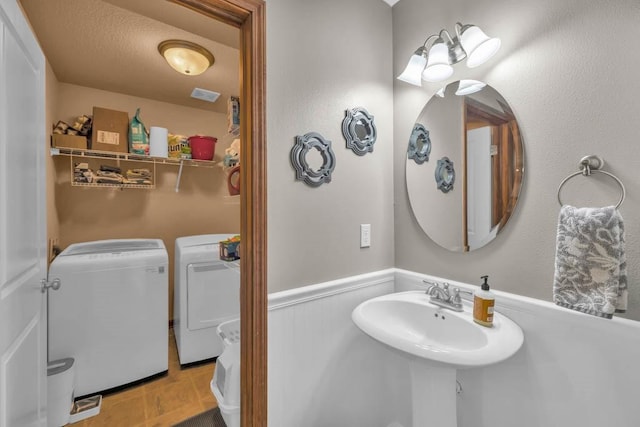1329 Joshua Cir SE, Bondurant, IA 50035 - bathroom featuring separate washer and dryer and wainscoting