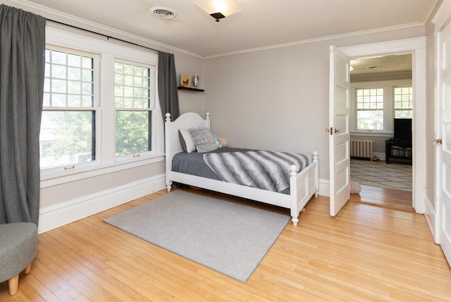 642 Polk Blvd, Des Moines, IA 50312 - bedroom featuring radiator heating unit, crown molding, and light wood finished floors