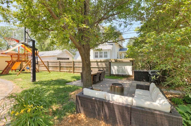 642 Polk Blvd, Des Moines, IA 50312 - fenced backyard with an outdoor living space with a fire pit, a patio, and a playground