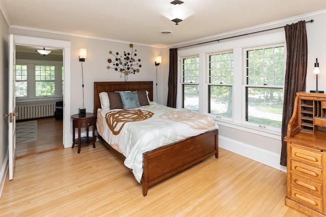 642 Polk Blvd, Des Moines, IA 50312 - bedroom featuring radiator, light wood-type flooring, and crown molding